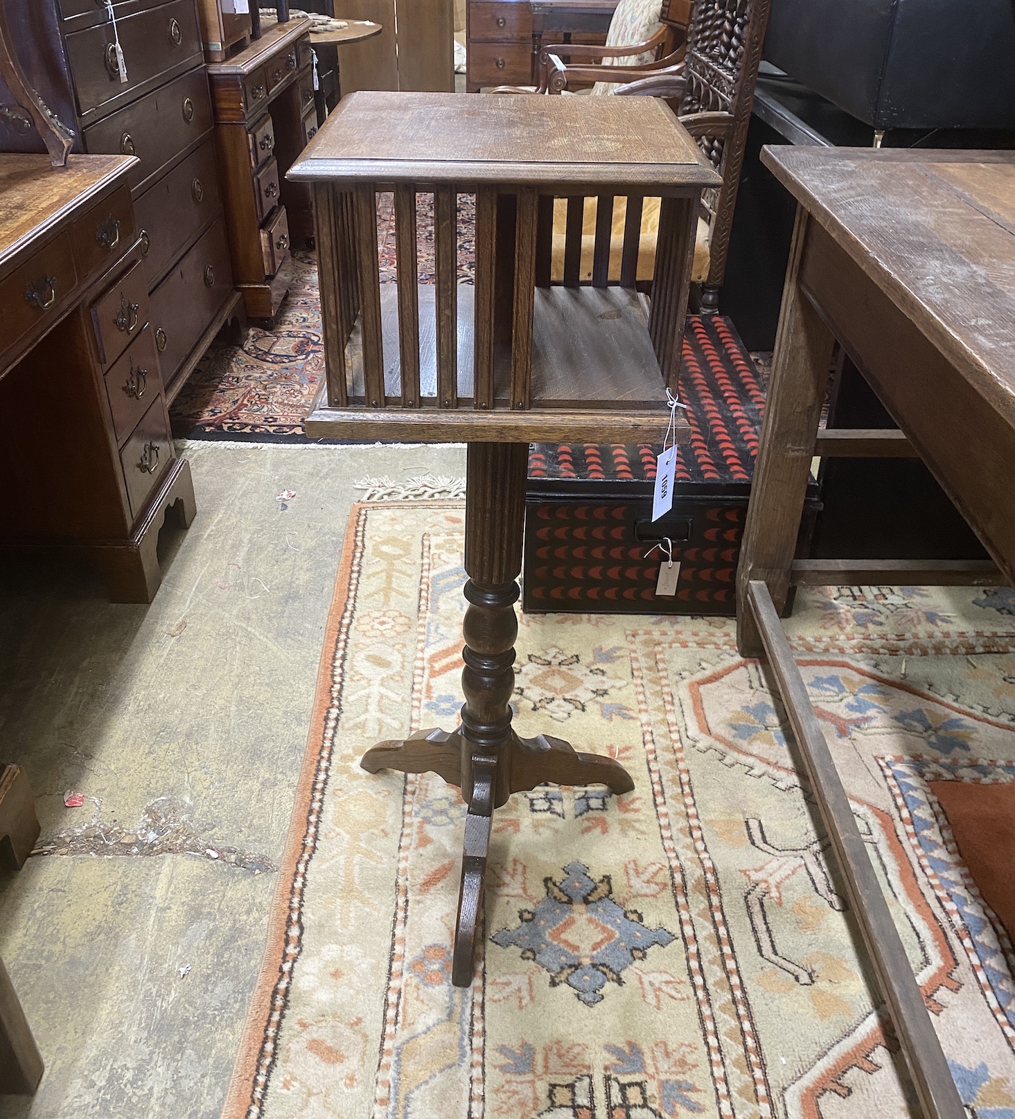An early 20th century oak revolving bookstand on a tripod base, width 35cm, height 97cm